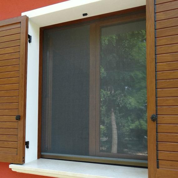 Zanzariera su finestra con scuri in legno, vista esterna